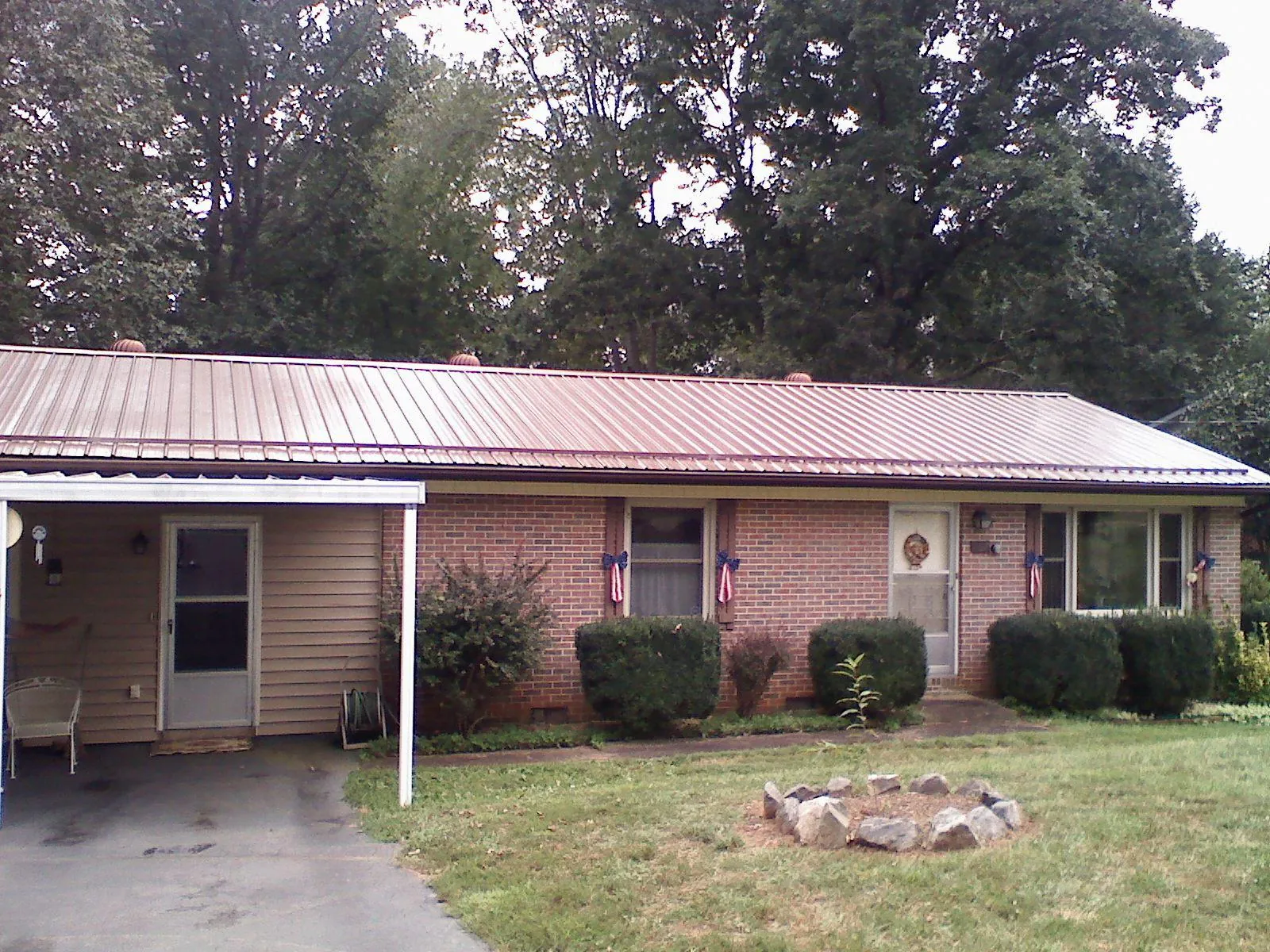 Bronze metal roof and carport on a brick ranch home — Roof Repair work by our crew in Gorham